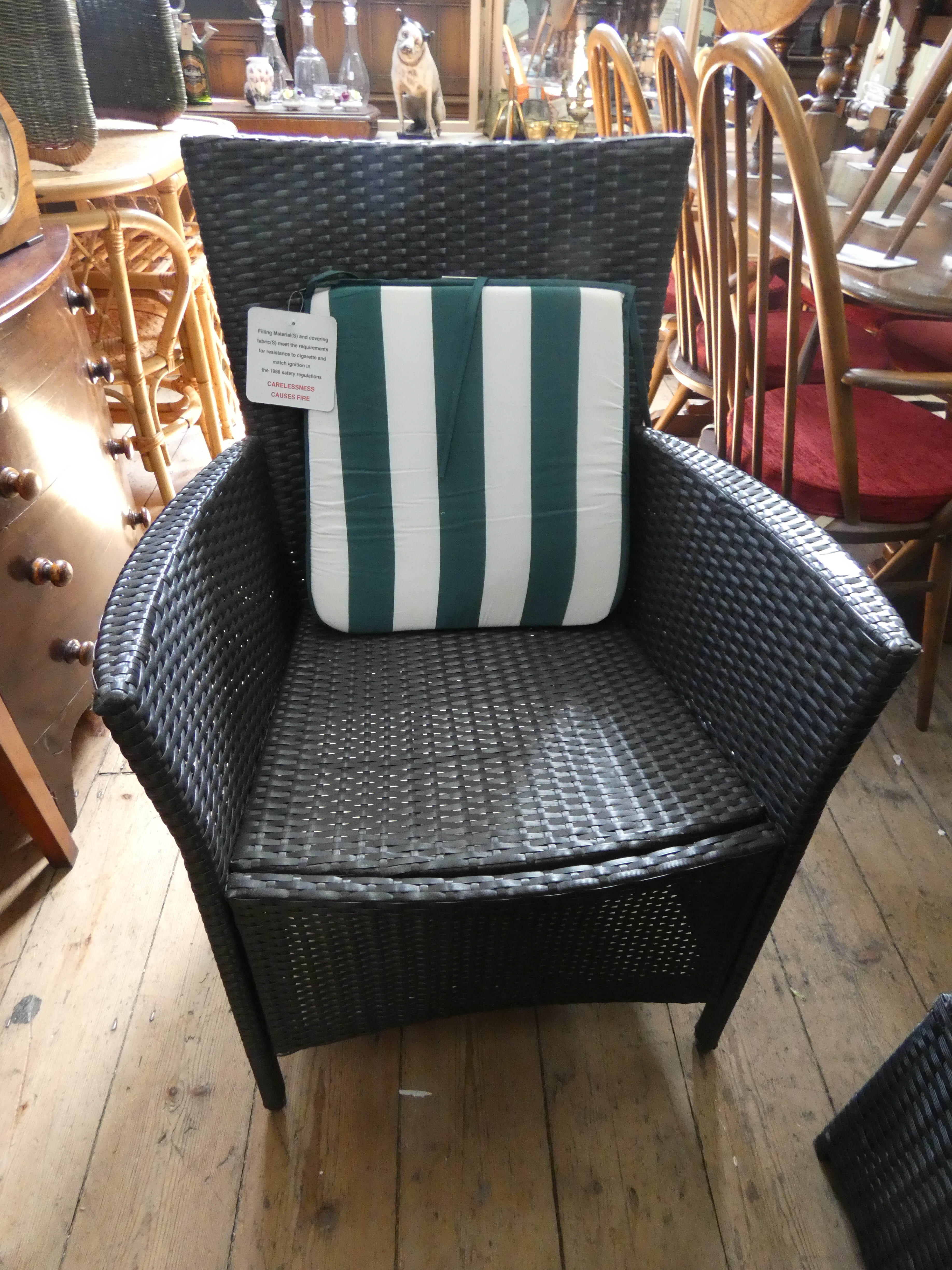 A pair of rattan style garden chairs with a small matching coffee tables