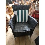 A pair of rattan style garden chairs with a small matching coffee tables