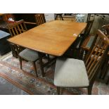 A 1970's GPlan teak drop leaf dining table and four matching slat back chairs with upholstered