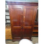 A modern mahogany two door wardrobe with interior mirror,