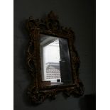 A wall mirror in decorative gilt frame