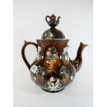 A Victorian barge ware teapot typically decorated with applied flowers and teapot finial,