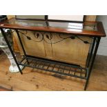 An iron framed two tier hall table with glass top