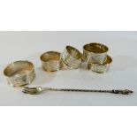 Five matching silver napkin rings and a silver pickle fork,