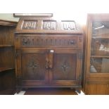 An old charm reproduction oak bureau with linen fold panel fall, drawer and cupboard under,