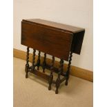 A small oak gate legged table on barley twist legs, stamped Waring and Gillow,