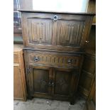 An old charm reproduction oak drinks cabinet with drawer and cupboards under with linen fold panel,