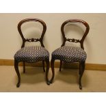 A set of four Victorian mahogany balloon backed dining room chairs standing on cabriole legs with
