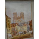 A pair of gilt framed watercolours of French street scenes with cathedrals in the background one is
