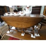 An Ercol Golden Dawn drop leaf coffee table standing on turned legs and stretcher base