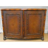 Mahogany bow front bamboo effect two door cupboard standing on carved feet with inset brown tooled