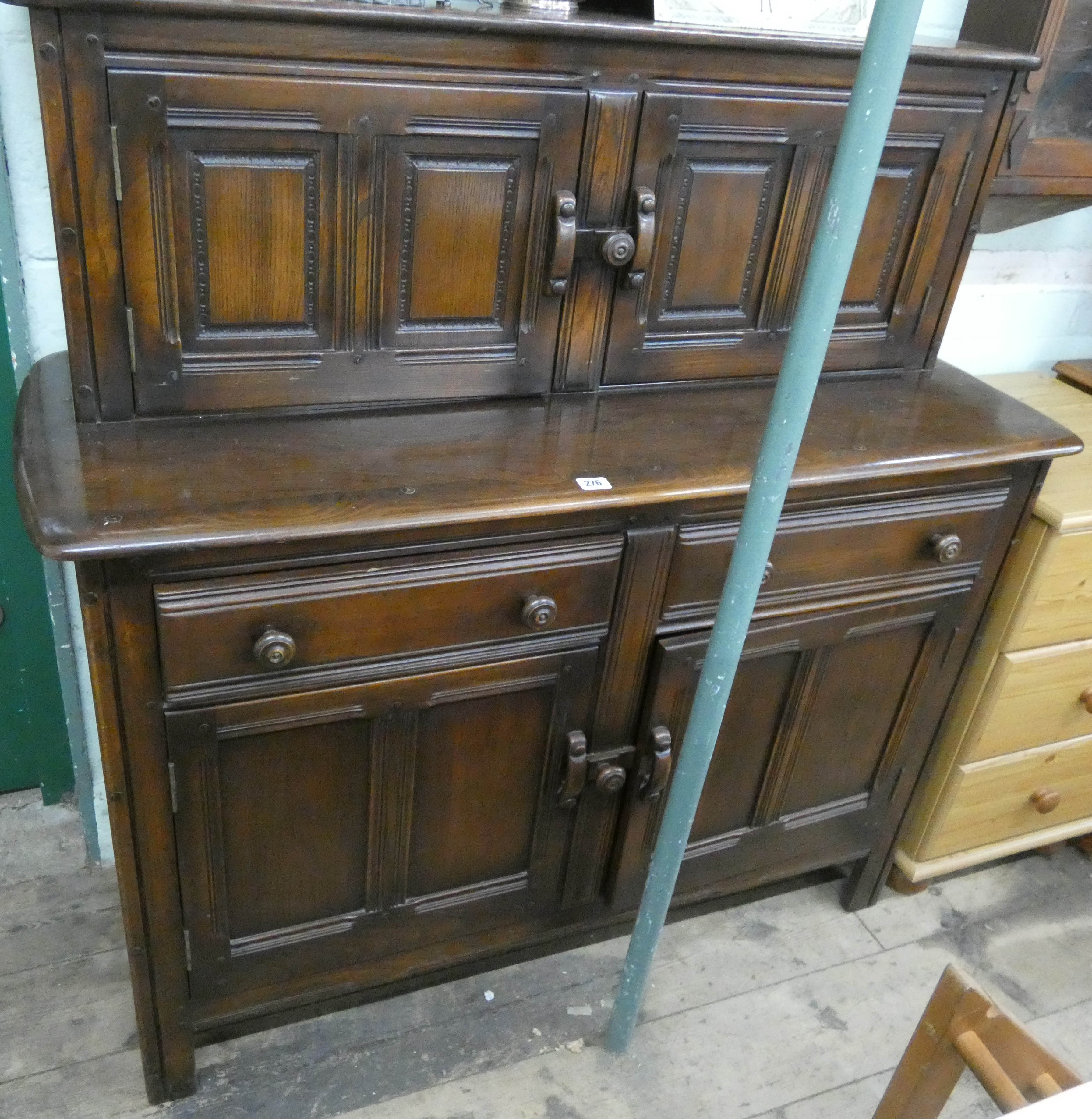 A reproduction Ercol oak court cupboard with a sliding cupboard back,