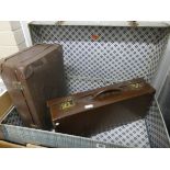 An old suitcase and two small brown leather suitcases