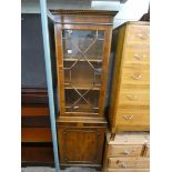 A reproduction yew wood glazed bookcase with cupboard under,