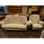 A GPlan style wood framed three seater settee in cream and floral patterned covering with one