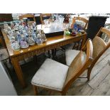 A light oak dining table with parquetry style top together with six caned backed dining room chairs