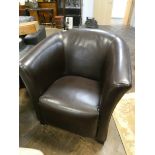 A tub shaped easy chair in brown leather