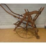 A child's Victorian rickshaw style cart with metal rimmed spoked wheels