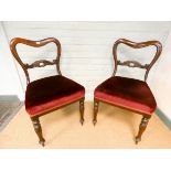 A set of six Victorian mahogany dining chairs with shaped balloon backs and red overstuffed velvet