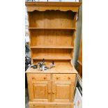 A pine kitchen dresser with shelf back, drawers and cupboards under,