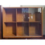 A light oak bookcase with sliding glass doors,
