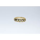 A five stone graduated diamond ring set in a yellow gold scroll setting, size M 1/2,