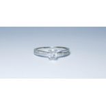A diamond solitaire ring set with an oval brilliant cut diamond with a crossover band with