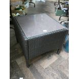 A rattan style small garden side table or footstool