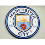 A circular cast iron Manchester City plaque