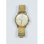 A vintage gents 9ct yellow gold Omega wrist watch with a metal expanding strap,