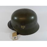 A German 2nd World War helmet still retaining its original decals and leather interior and straps,