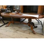 A large oval mahogany coffee table on refectory style base