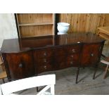 A Georgian style reproduction mahogany shaped front sideboard fitted three centre drawers standing