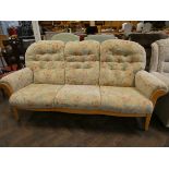 A GPlan style three seater settee in cream and floral covering