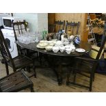 An Ercol oak oval extending dining table with centre leaf and six high spindle back chairs (no seat