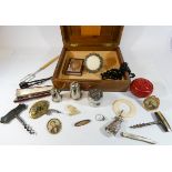 A wooden box containing jet beads, rabbit shaped teething rattle ring, corkscrews,