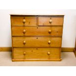 A Victorian stripped pine chest of three long and two short drawers with bun handles,