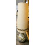 A very large china table lamp with tall material shade