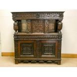 An Elizabethan style carved oak court cupboard with a provenance plaque inside the door - ex