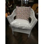 A white cane elbow chair with loose cushions