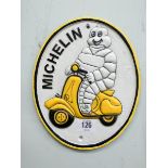 A cast iron oval Michelin Man on a scooter