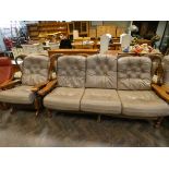 A wood framed three seater settee three piece lounge suite with beige loose leather covered