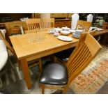 A good quality heavy light oak extending dining table with two extra leaves,