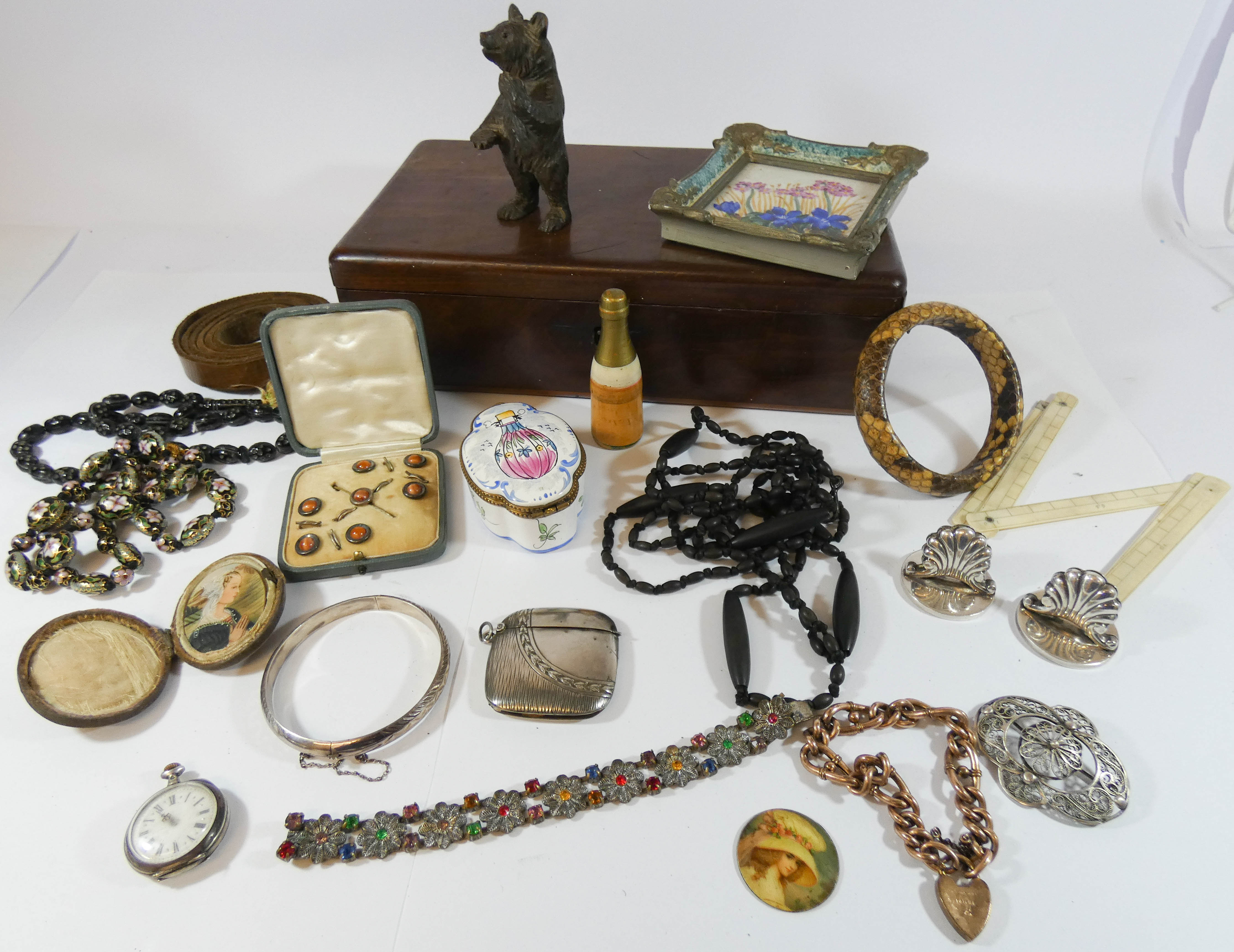 A hardwood box to contain carved treen bear, gilt metal gate bracelet cloisonne and other beads,