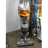 A silver and orange Dyson upright vacuum cleaner