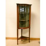 An Edwardian inlaid mahogany serpentine fronted glazed corner display cabinet with under tier