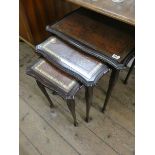 A nest of three reproduction coffee tables with leather and glass tops