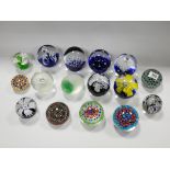 A collection of 16 assorted glass paperweights