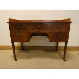 A Victorian mahogany tray topped, kneehole desk fitted five drawers on turned legs,