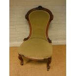 A Victorian walnut spoon back occasional chair standing on cabriole legs upholstered in green